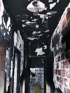 Este es el pasillo de la casa. El grado de calcinación es terrible. El fuego ha arrancado yeso y cemento de techos y paredes, todo está calcinado. Al fondo se ve los azulejos de la pared del baño